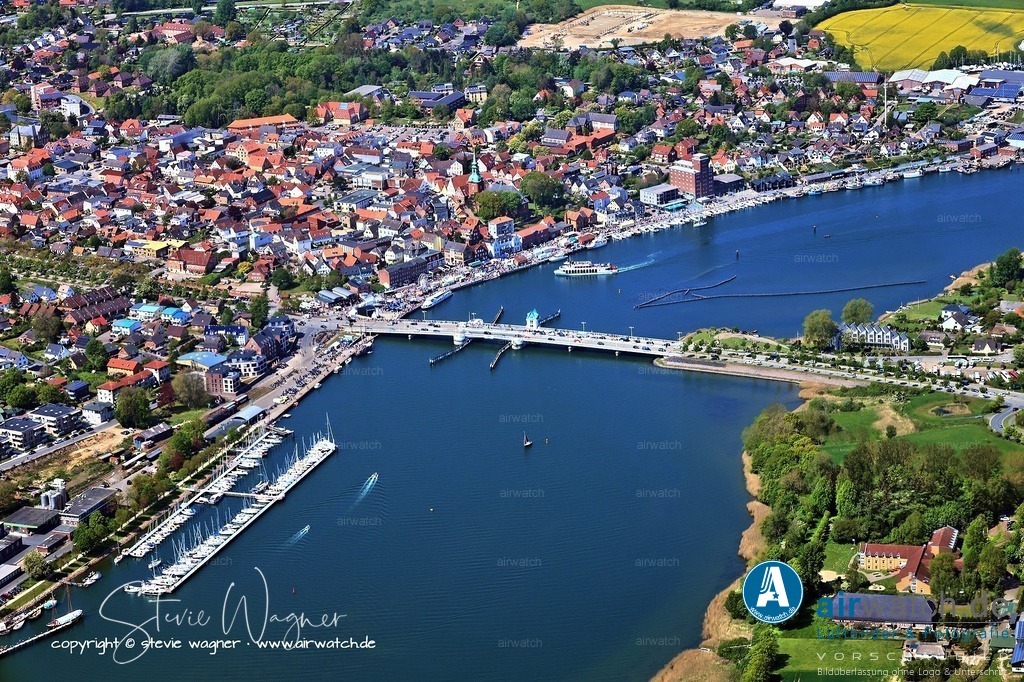 Luftbild Kappeln an der Schlei | Kappeln an der Schlei wurde erstmals 1357 urkundlich erwähnt, wobei der Ortsname etymologisch von der Kapelle abgeleitet ist, die bereits im 14. Jahrhundert am hohen Schleiufer stand. Ursprünglich entwickelte sich der Ort als Fischerdorf und sicherer Hafen für Seefahrer auf dem Weg nach Haithabu, was zur Gründung der St. Nikolaikirche beitrug.