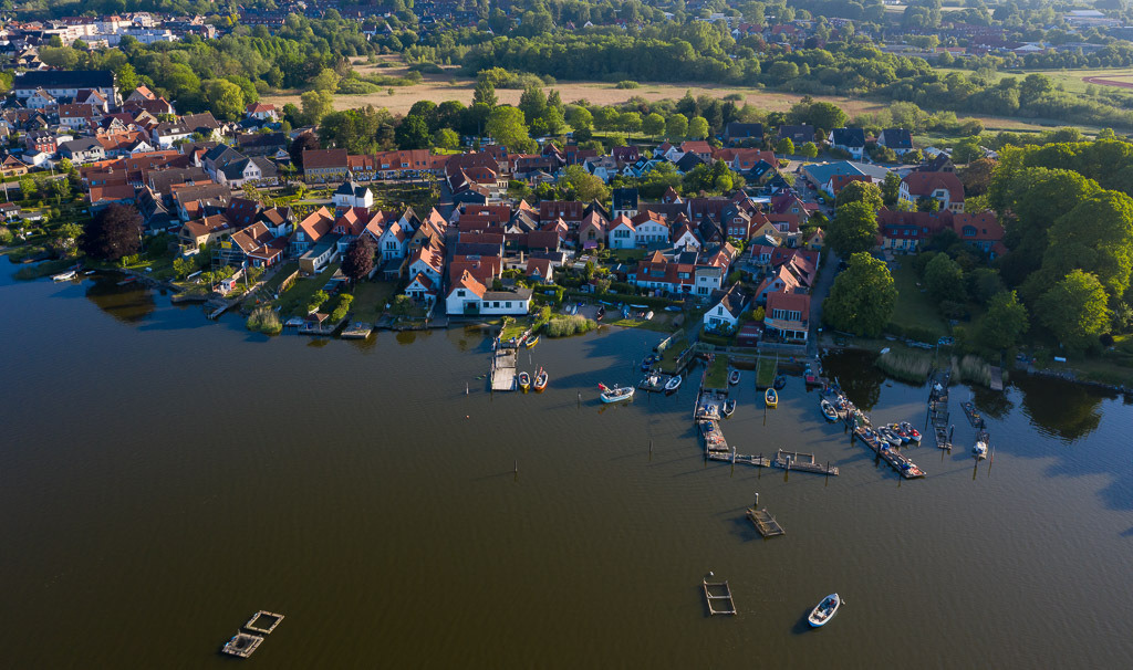 deutschland-2020-099 | Luftaufnahme der Fischersiedlung Holm in Schleswig an der Schlei. Das Bild entstand kurz nach Sonnenaufgang. An den Brücken sind die offenen Motorboote der Holmer Fischer zu erkennen. - Realisiert mit Pictrs.com