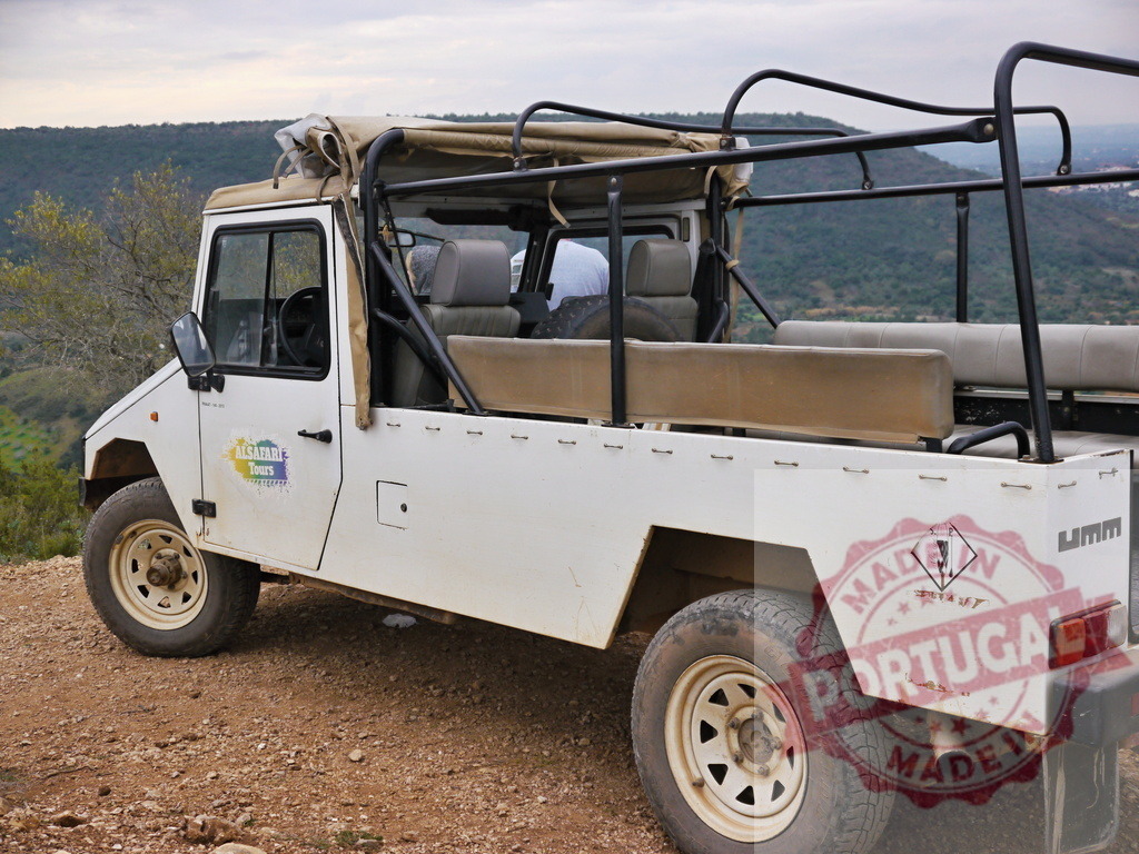 Safari vehicle parked on rugged mountain terrain | White safari vehicle parked on a dirt road, ready for adventure travel - Realized with Pictrs.com
