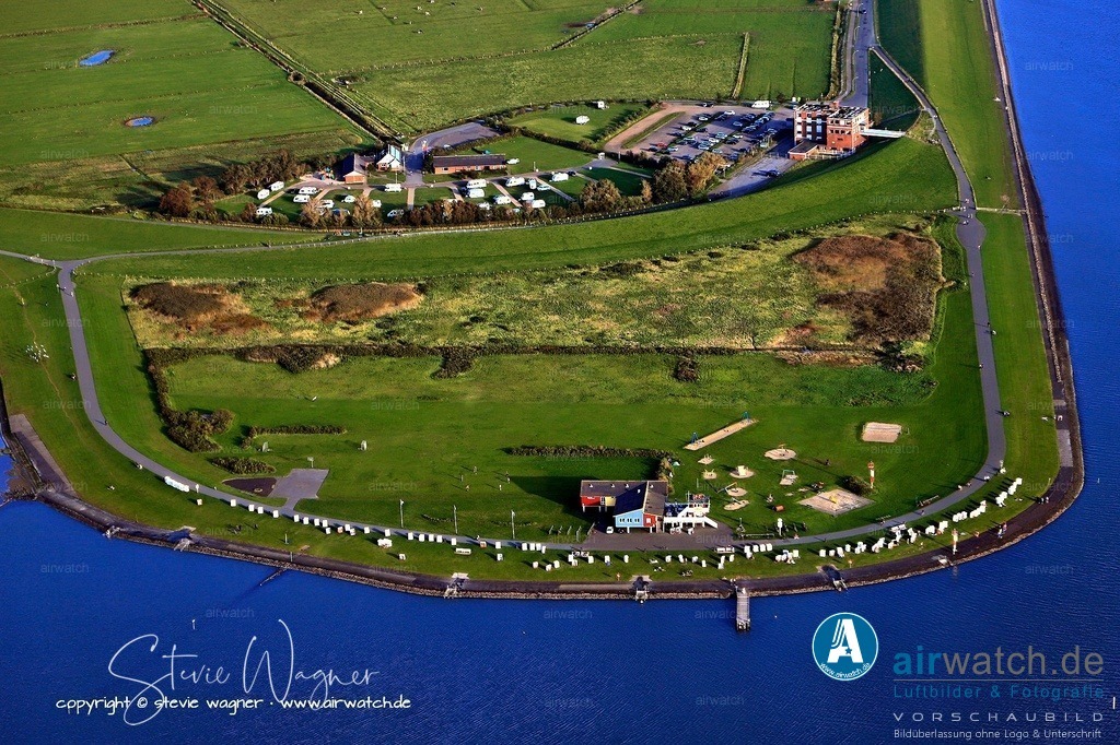 Luftbild Husum - Dockkoogspitze | Die Anreise erfolgt bequem mit dem Auto, Fahrrad oder öffentlichen Verkehrsmitteln. Der „Dockkoog-Shuttle“ wurde 2024 eingeführt und verkehrt zwischen dem 3. Mai und dem 28. September 2025 an Wochenenden und Sonntagen zwischen der Innenstadt und der Dockkoogspitze. Für Fahrradfahrer steht das Velobike zur Verfügung, das ebenfalls zwischen dem Rathaus-Turm und dem Dockkoog pendelt. Ein Strandkorb kann am Dockkoog gemietet werden, und die WunderBar serviert Snacks und Getränke.