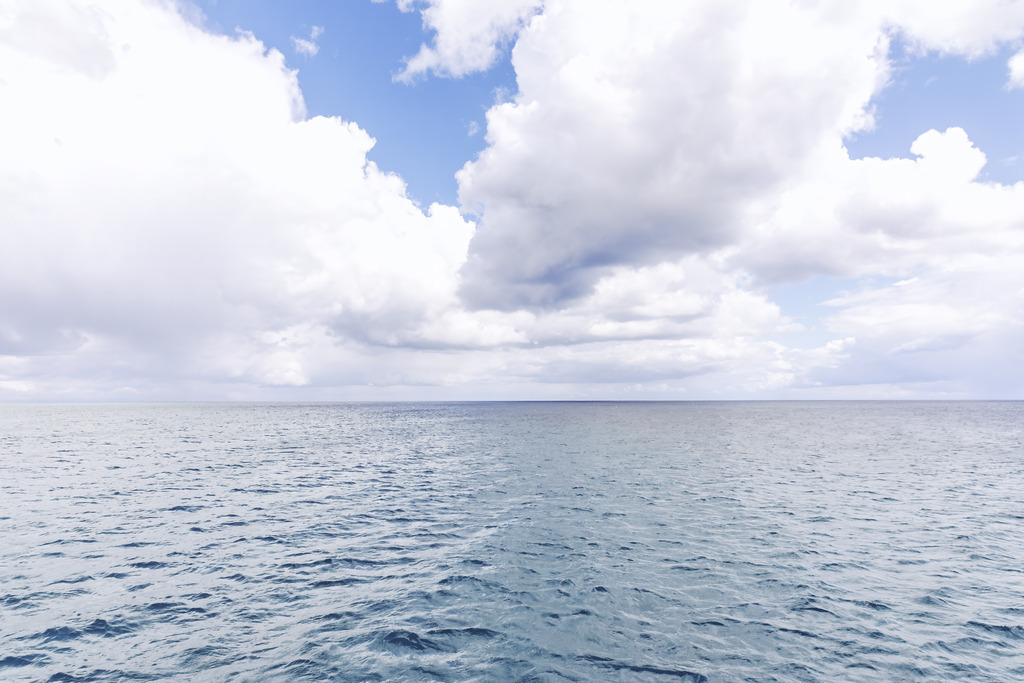 Weite Wolkenlandschaft über bewegtem Meer – Minimalistische Meeresfotografie | Über dem weit ausgebreiteten Meer türmen sich helle Wolken, die dem Motiv eine eindrucksvolle Tiefe und eine natürliche Leichtigkeit verleihen. Die feinen Bewegungen der Wasseroberfläche stehen im spannenden Kontrast zu den weichen Strukturen des Himmels und erzeugen eine ruhige, aber lebendige Atmosphäre. Die klare Horizontlinie und die ausgewogene Farbgebung unterstreichen den minimalistischen Charakter des Bildes und lassen es besonders harmonisch wirken. Dieses Fine‑Art‑Wandbild bringt eine elegante, luftige Weite in moderne Räume und setzt einen hochwertigen Akzent, der sowohl beruhigt als auch inspiriert.