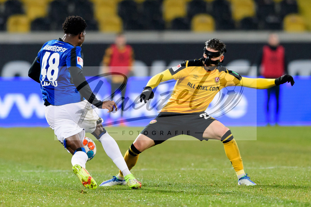 SGDHSV20220114_037 | Fussball, Herren: Faride Alidou (Hamburger SV) und Brandon Borrello (SG Dynamo Dresden) im Zweikampf bei dem Spiel der 2. Bundesliga zwischen SG Dynamo Dresden und Hamburger SV im Rudolf-Harbig-Stadion am 14.01.2022 in Dresden, Deutschland.DFB / DFL REGULATIONS PROHIBIT ANY USE OF PHOTOGRAPHS AS IMAGE SEQUENCES AND/OR QUASI-VIDEO. - Realisiert mit Pictrs.com