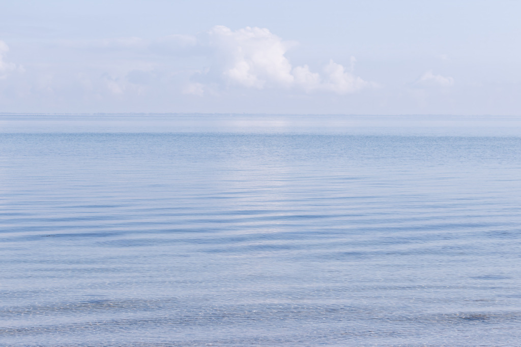 Wandbild: Himmelsspiegel Ostsee - Sanfte Wellen bei Falshöft | Dieses minimalistische Wandbild fängt die friedvolle Weite der Ostseeküste in Falshöft in vollkommener Klarheit ein. Die zarten Blautöne des Wassers im Vordergrund gehen fließend in den fernen Horizont über, während sich darüber ein malerischer Wolkenhimmel spannt. Die harmonische, reduzierte Komposition vermittelt eine tiefe, meditative Ruhe – eine stilvolle Bereicherung für anspruchsvolle, moderne Interieurs mit einem Gespür für zeitlose Ästhetik.