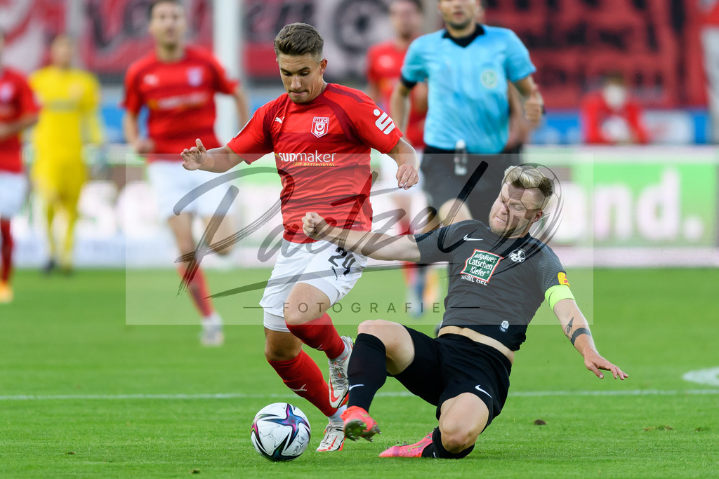 HFCFCK20210824_028 | Fussball, Herren: Julian Guttau (Hallescher FC) und Jean Zimmer (1. FC Kaiserslautern) im Zweikampf beim Spiel der 3. Liga zwischen Hallescher FC und 1. FC Kaiserslautern im Leuna-Chemie-Stadion am 24.08.2021 in Halle (Saale), Deutschland. - Realisiert mit Pictrs.com