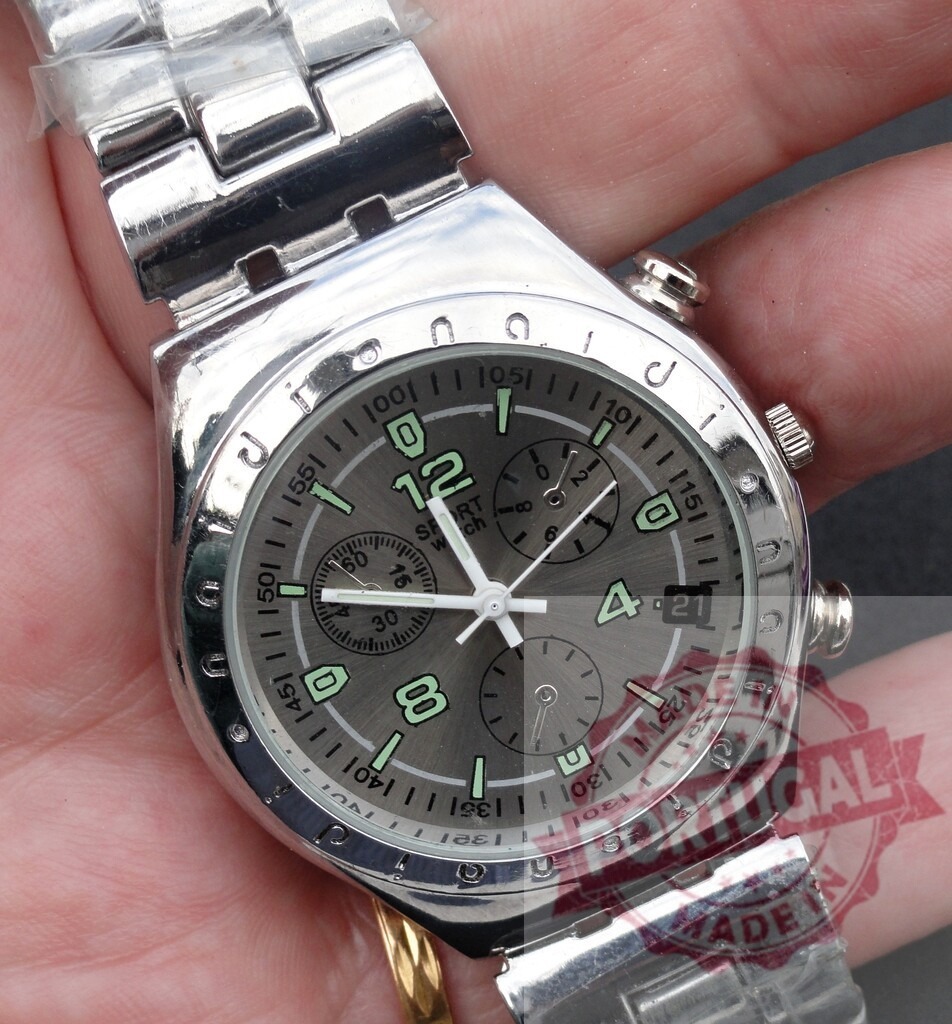 Hand holding silver sport chronograph watch | Hand holding a modern silver tone chronograph sport watch with a metal band - Realized with Pictrs.com