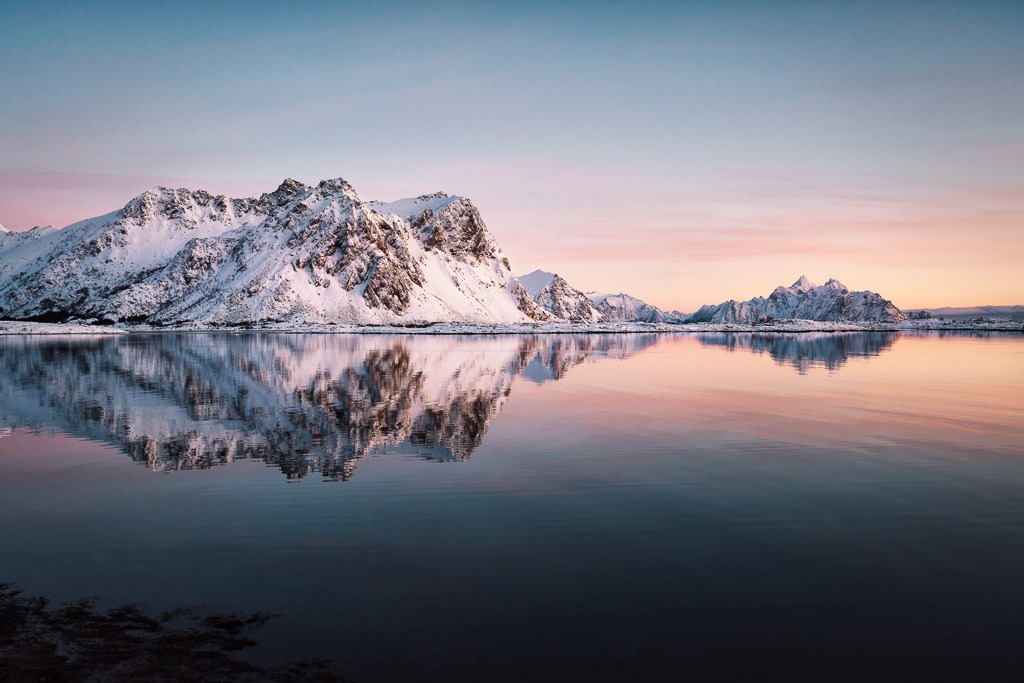Winterspiegelung – Valberg, Lofoten | Zarte Farben, klare Linien: Bei Valberg auf den Lofoten spiegeln sich schneebedeckte Berge im ruhigen Wasser. Das pastellige Licht verleiht der Szene eine besondere Ruhe – perfekt für alle, die minimalistische Winterlandschaften lieben. - Realisiert mit Pictrs.com