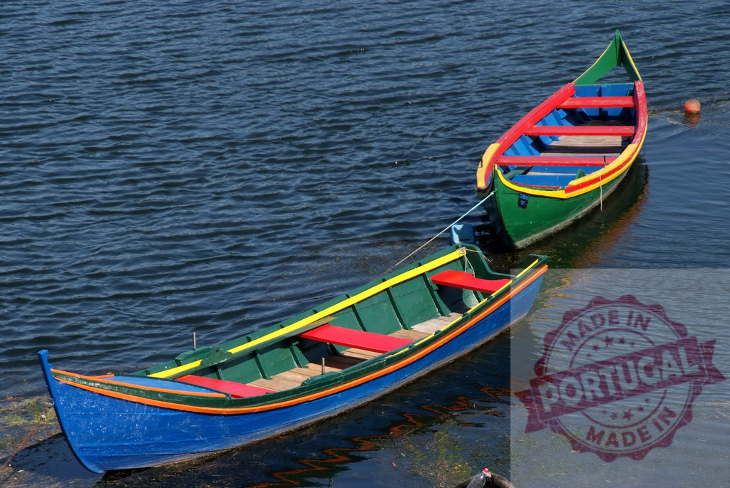 Moliceiro boats on blue water in Aveiro Portugal. Centro Portugal | Colorful Moliceiro boats floating on a lagoon in Aveiro, Portugal - Realisiert mit Pictrs.com