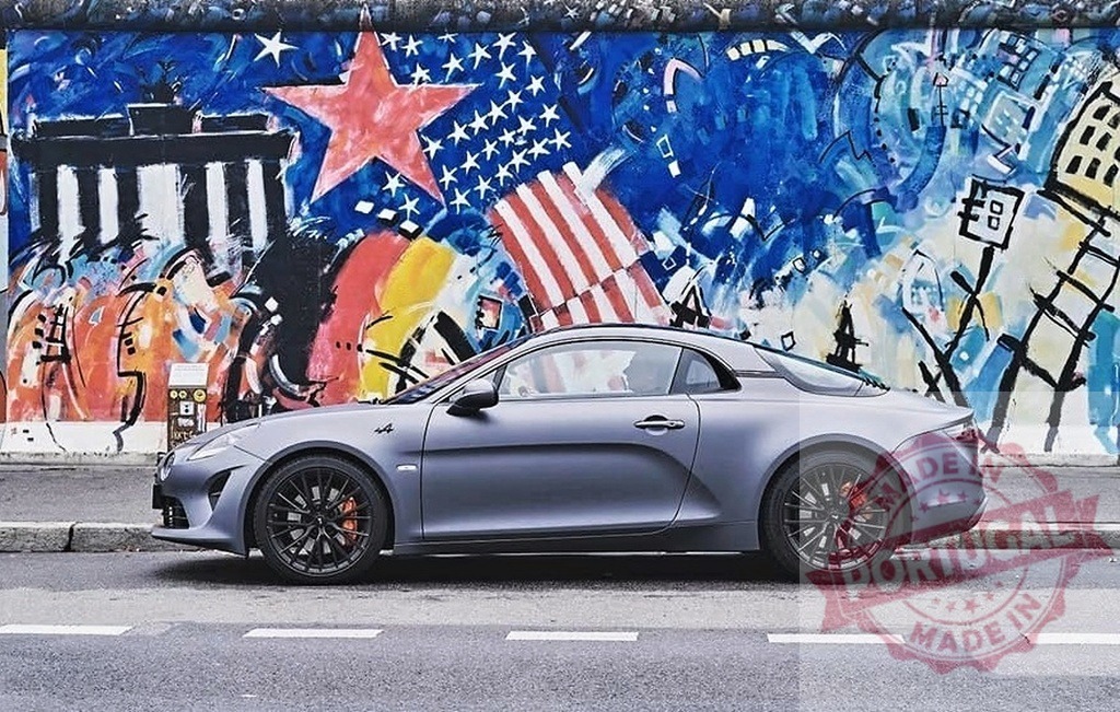 Alpine A110 sports car parking by Berlin Wall | Alpine A110 sports car standing on a street next to the colorful East Side Gallery - Realisiert mit Pictrs.com