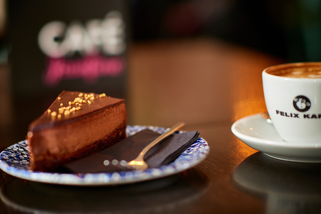 Cafe Josefine | WIen, Austria - February 13, 2018: Cafe Josefine; auf dem Tisch stehend eine Chocolate de Luxe Torte mit einer Tasse Felix Kaffee und einer Speisekarte. - Realisiert mit Pictrs.com