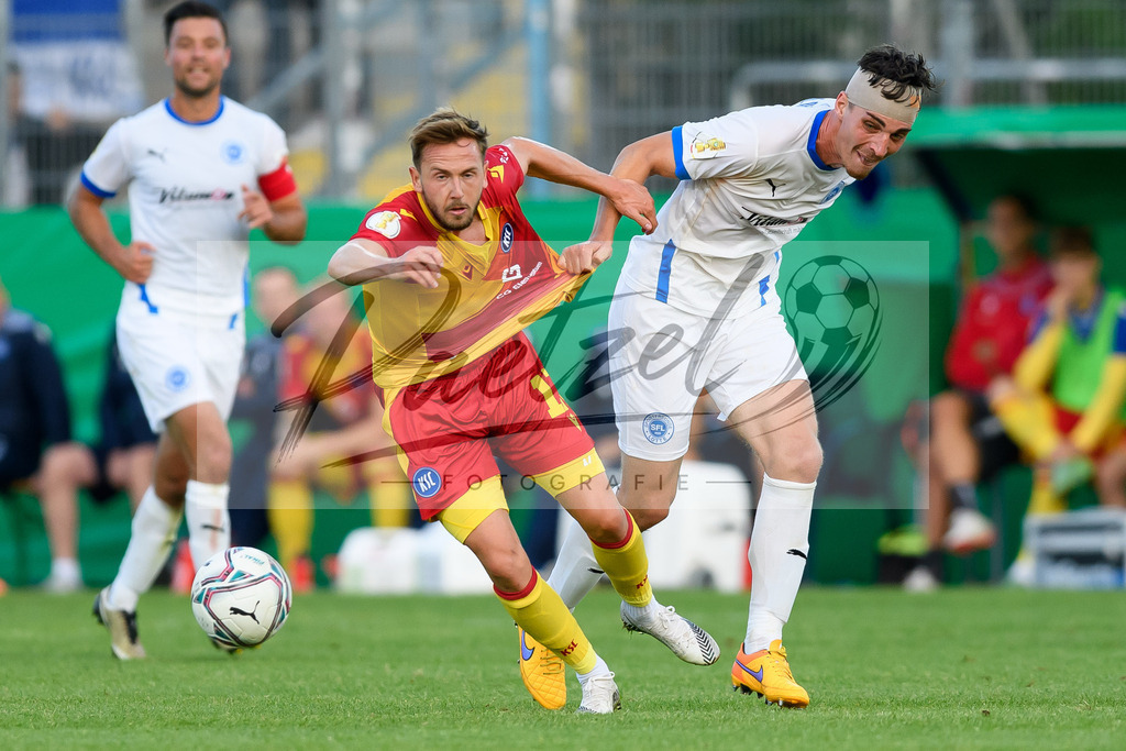 LOTKSC20210809_057 | Fussball, Herren: Lucas Cueto (Karlsruher SC) und Luis Allmeroth (Sportfreunde Lotte) im Zweikampf beim Spiel der 1. Runde im DFB-Pokal zwischen SF Lotte und Karlsruher SC im Stadion am Lotter Kreuz am 09.08.2021 in Lotte, Deutschland.DFB / DFL REGULATIONS PROHIBIT ANY USE OF PHOTOGRAPHS AS IMAGE SEQUENCES AND/OR QUASI-VIDEO. - Realisiert mit Pictrs.com