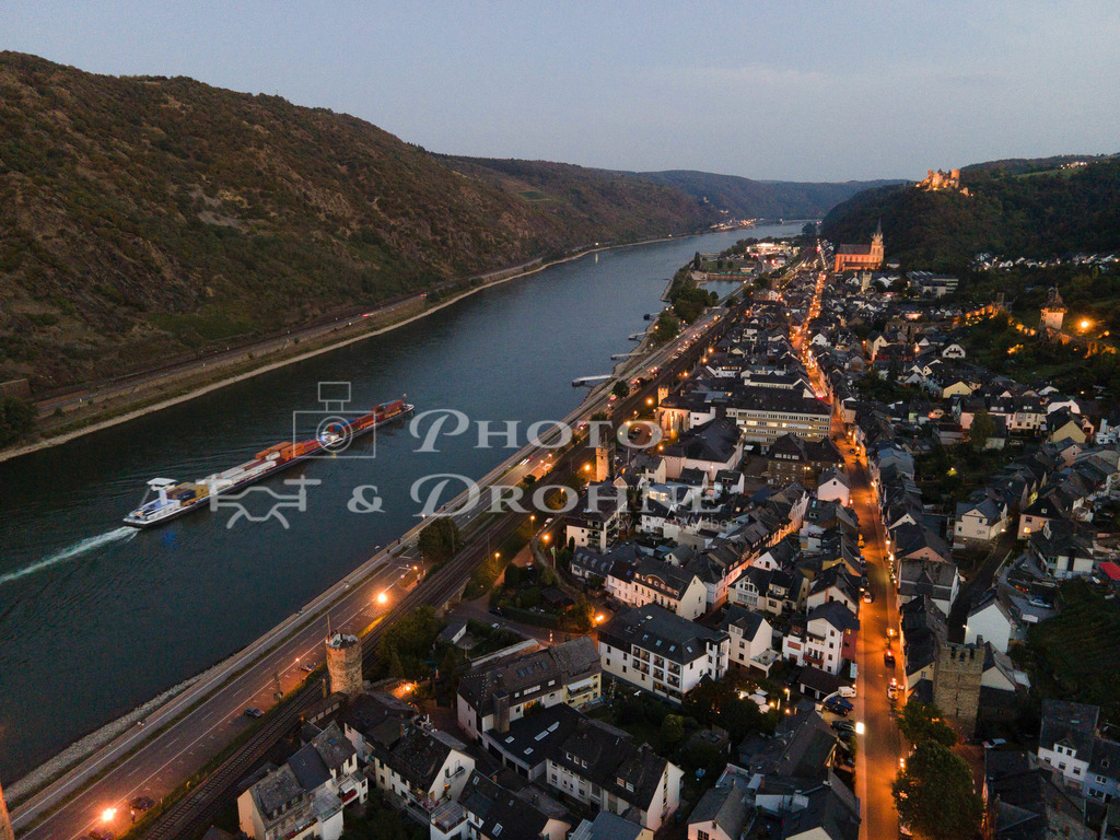Oberwesel-94 | Abendstimmung in Oberwesel am Rhein bei eingeschalteter Straßenbeleuchtung und eiem Schiff auf dem Wasser. - Realisiert mit Pictrs.com