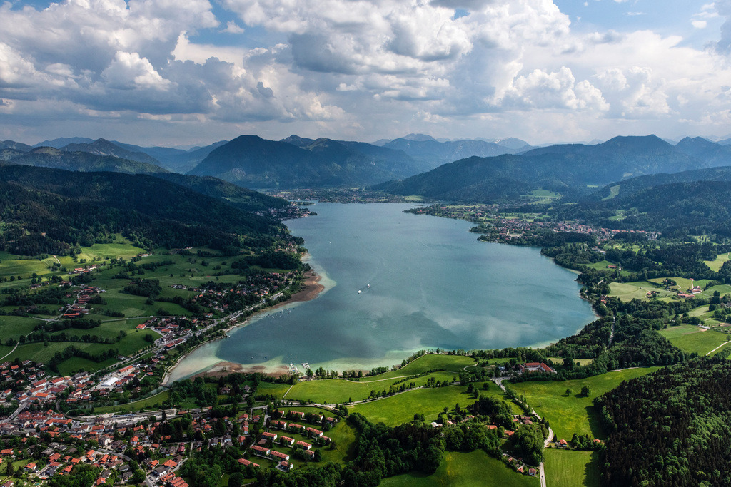 dr__0098017.jpg | BAD WIESSEE 19.05.2022 Der Tegernsee in den Bayerischen Alpen im Bundesland Bayern zählt zu den saubersten Seen Deutschlands und ist ein beliebtes Ausflugs- und Fremdenverkehrsziel. Es ist außerdem wichtig für die Trinkwasserversorgung und als Hochwasserrückhaltebecken. Aufnahme bei bewölktem Himmel mit Schattenwurf der Wolken auf der Seefläche. // Riparian areas on the lake area of Tegernsee in Bad Wiessee in the state Bavaria, Germany. Foto: Daniel Reiter