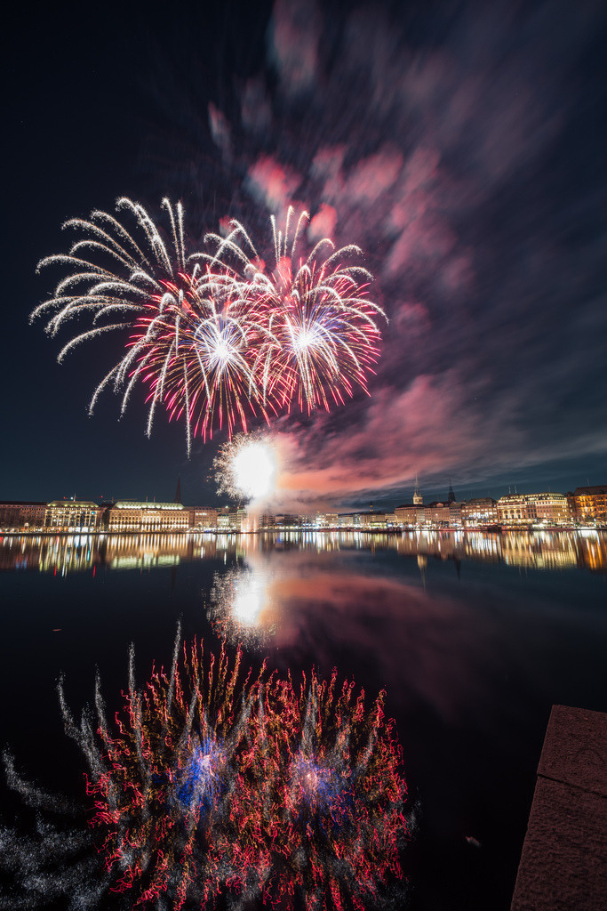 Feuerwerk zwischen Himmel und Alster | Das Feuerwerk scheint zwischen dem Hamburger Nachthimmel und seiner Spiegelung auf der Alster zu schweben. Eine symmetrisch wirkende Nachtaufnahme voller Licht und Farbe. - Realisiert mit Pictrs.com