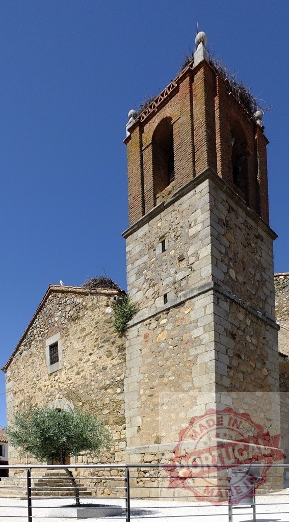 Historic stone bell tower with stork nests under blue sky. Spain - Extremadura | Ancient church tower built of stone and brick, featuring active stork nests - Realisiert mit Pictrs.com
