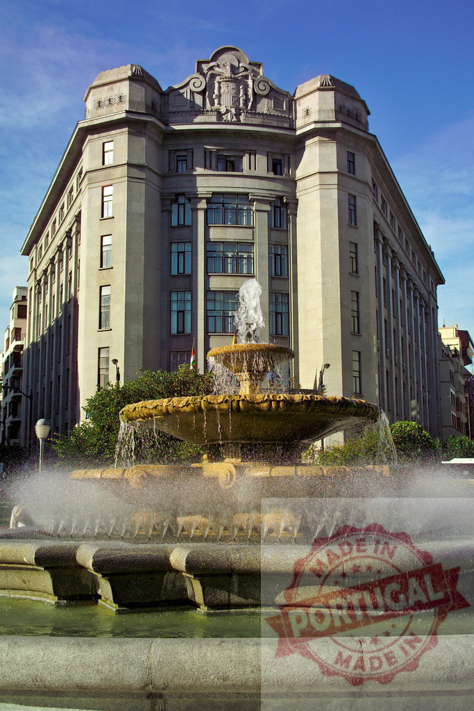 Plaza de Moyúa fountain spraying water in Bilbao. Spain - Bilbao | Plaza de Moyúa fountain spraying water with Palacio de Chávarri building in the background - Realized with Pictrs.com