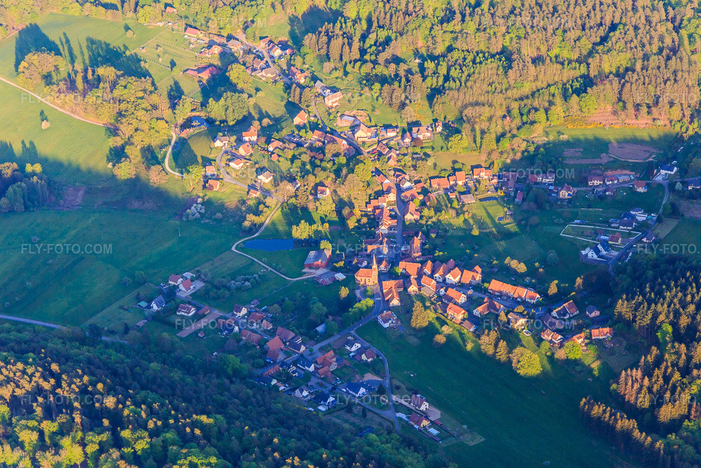 Aerial view: Village view in the Northern Vosges Mountains from the north in Zittersheim in the state Bas-Rhin, France. – Photo: IMG_145836.jpg taken on 04/30/2025 by Werner Riehm/FLY-FOTO.com – Resolution of the original: 5472 x 3648 px