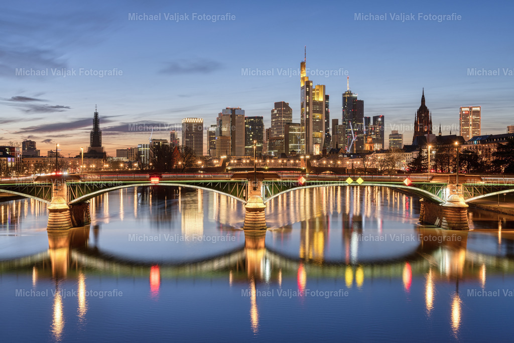Frankfurt am Abend | Blick von der Flößerbrücke zur Ignatz-Bubis-Brücke und den Hochhäusern im Bankenviertel. Abends nach Sonnenuntergang zur blauen Stunde wird es richtig schön bunt in Frankfurt, die vielen Lichter verleihen der Stadt einen einzigartigen Anblick. - Realisiert mit Pictrs.com