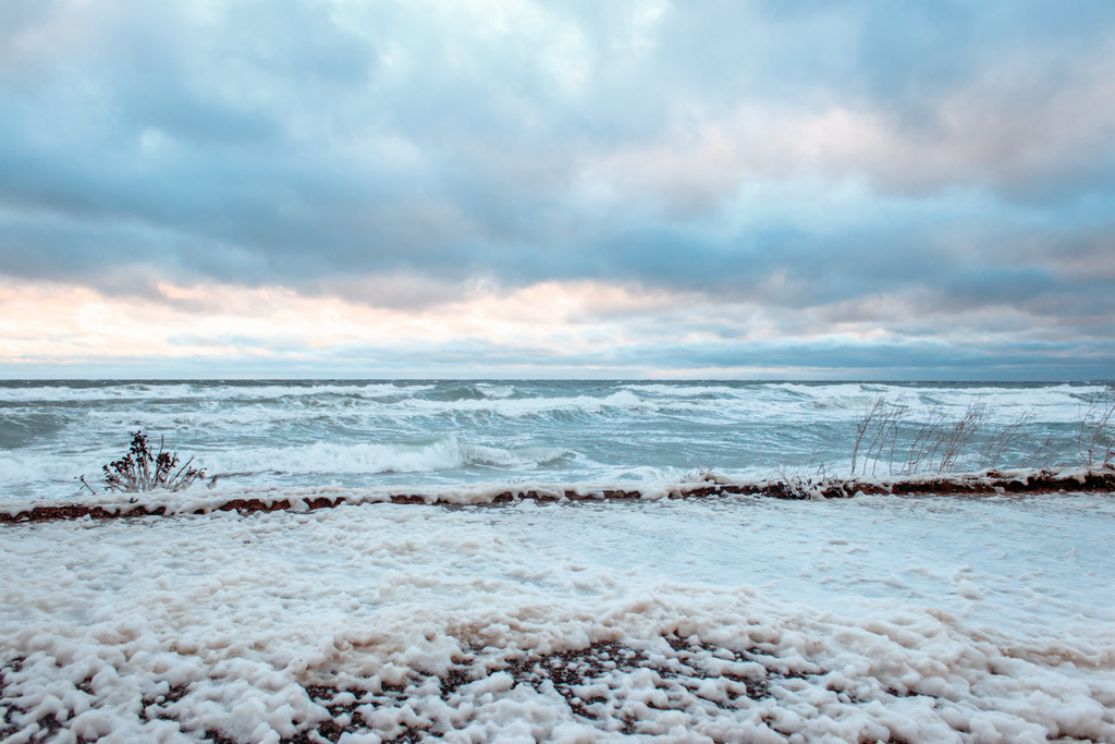 Wandbild: Wellen, Wolken und Gischt in dezenten Farben | Dieses Wandbild im Querformat zeigt Wellen und Gischt am und Meer und dem angrenzenden Wanderweg in überwiegend hellen Farben. Durch die Gischt hat das Wandbild viele helle Bestandteile. Der Himmel auf diesem Bild ist auch sehr malerisch. Die Wolken werden teilweise vom roten Licht der aufgehenden Sonne angeleuchtet. Kaufen Sie sich diese schöne maritime Morgenstimmung auf Leinwand, Aluminium-Platte oder Acrylglas. Ideal fürs Wohnzimmer, Schlafzimmer, Küche, den Arbeitsplatz oder die Ferienwohnung. Die Wandbilder werden individuell für Sie in vielen Abmessungen produziert. Daher passen die Ostseekult Wandbilder immer perfekt an Ihre Wände. - Realisiert mit Pictrs.com