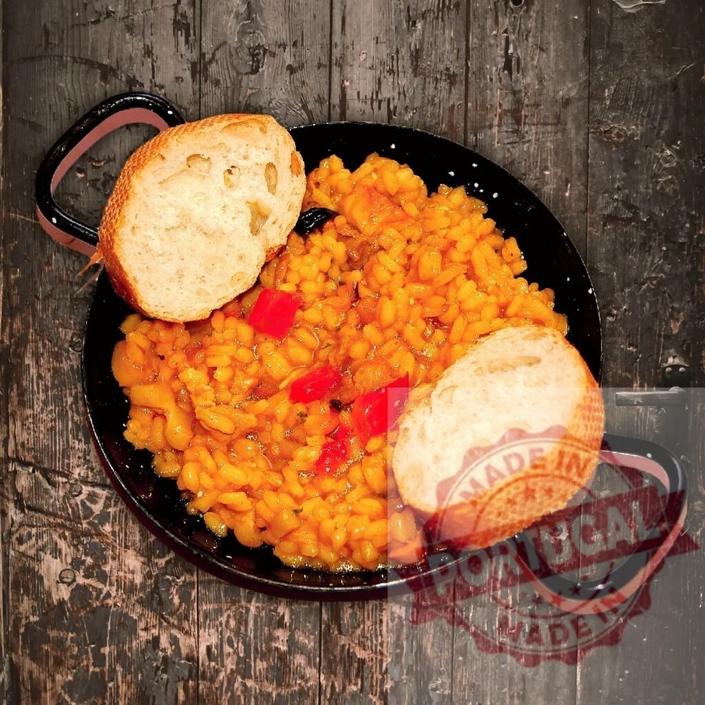 Spanish paella in pan with bread | Paella serving traditional Spanish food with rice and red pepper in a pan - Realized with Pictrs.com