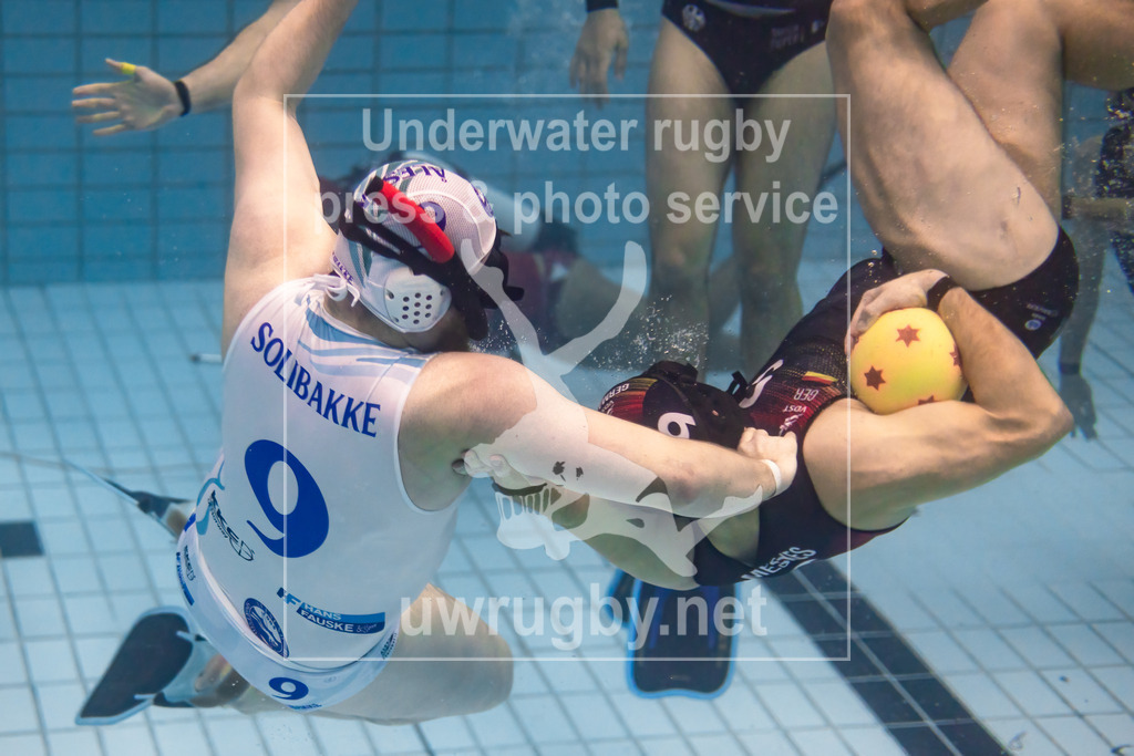 24. - 26.11.2023: Unterwasser-Rugby Champions Cup 2023  | Herren-Halbfinale: DUC Krefeld (Deutschland) in blau gegen Ålesund (Norwegen) in weiß. Per Solibakke (weiß #9) versucht den Krefelder Lucas Meskes (blau #9) in der Spielfeldmitte zu stoppen. - Realisiert mit Pictrs.com