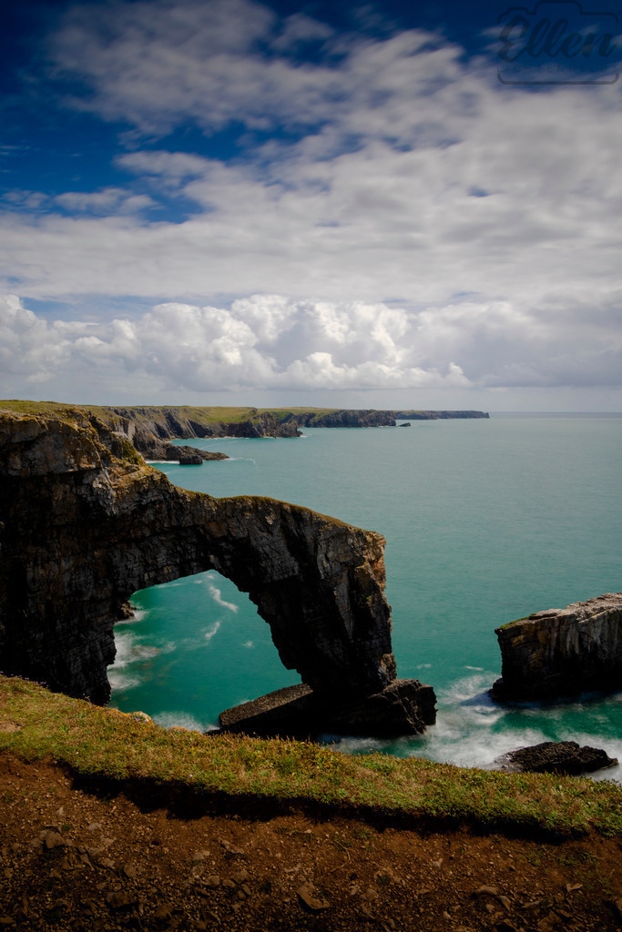 Gateway to the Sea | The Green Bridge of Wales rises from the cliffs like a natural monument shaped by wind and tide. Here, land surrenders to the ocean — a timeless meeting of strength and serenity. - Realisiert mit Pictrs.com