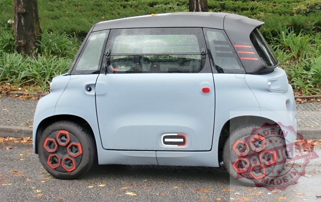 Citroen Ami electric microcar parking on urban street | Citroen Ami electric quadricycle standing on the curb, representing sustainable city transport - Realisiert mit Pictrs.com