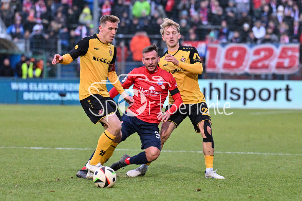 SpVgg Unterhaching - Dynamo Dresden | v. l. Niklas HAUPTMANN (Dynamo Dresden 27) / Simon SKARLATIDIS (UHG #30) und Sascha RISCH (Dynamo Dresden 28) / Zweikampf / 3. Liga: SpVgg Unterhaching - Dynamo Dresden, Uhlsportpark am 21.12.2024