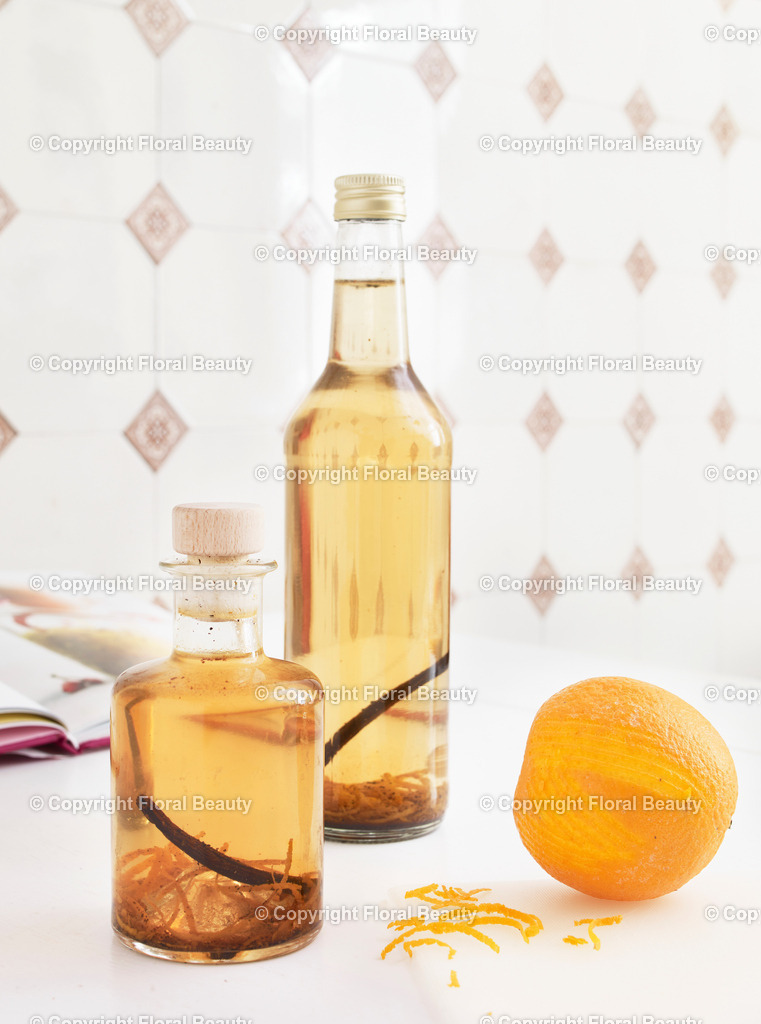 Vanille-Orangen-Likörgeschenk | Zwei Flaschen Vanille-Orangen-Likör vor gefliester Wand. Orangenzesten - Realisiert mit Pictrs.com