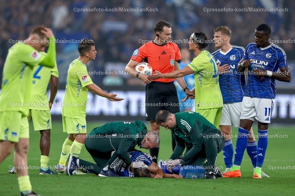 S0401082501134 | 01.08.2025, Fußball, FC Schalke 04 - Hertha BSC, 1.Spieltag, 2. Fußball Bundesliga, Veltins-Arena Gelsenkirchen, Saison 2025 2026: Nikola Katic (Schalke04 #25) liegt verletzt am Boden und muss mit einer Verletzung am Kopf Ohr behandelt werden DFB regulations prohibit any use of photographs as image sequences and or quasi-video.