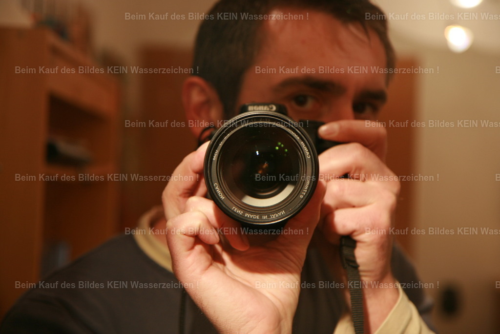 Fotograf_Lehmann_1 | Der Blick hinter das Objektiv---Dieses Selbstporträt entstand mit meiner ersten digitalen Spiegelreflexkamera. Eigentlich ist es ein Blick in den Spiegel – und doch wirkt es so, als würde ich den Betrachter direkt ansehen. Genau dieser Moment gefällt mir bis heute.---Damals war die digitale Fotografie noch etwas Besonderes. Jede neue Kamera eröffnete neue Möglichkeiten und ich verbrachte viele Stunden damit, ihre Technik kennenzulernen und mit Licht, Perspektiven und Bildgestaltung zu experimentieren. --- Die Kameras haben sich verändert, die Technik ist moderner geworden und meine Motive sind heute oft Luftbilder aus dem Tragschrauber. Doch die Begeisterung, durch den Sucher zu schauen und den richtigen Moment festzuhalten, ist dieselbe geblieben. - Realisiert mit Pictrs.com
