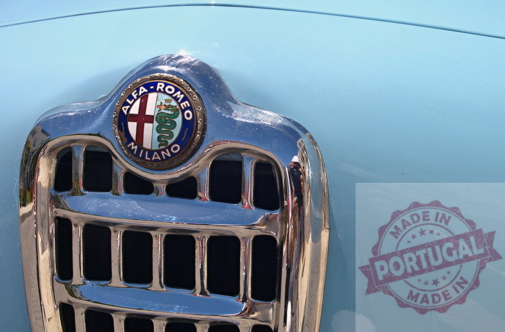 Shiny chrome Alfa Romeo grille reflecting sunlight on classic vintage car | Close-up of an Alfa Romeo logo on a light blue classic car, highlighting the shiny chrome grille - Realisiert mit Pictrs.com