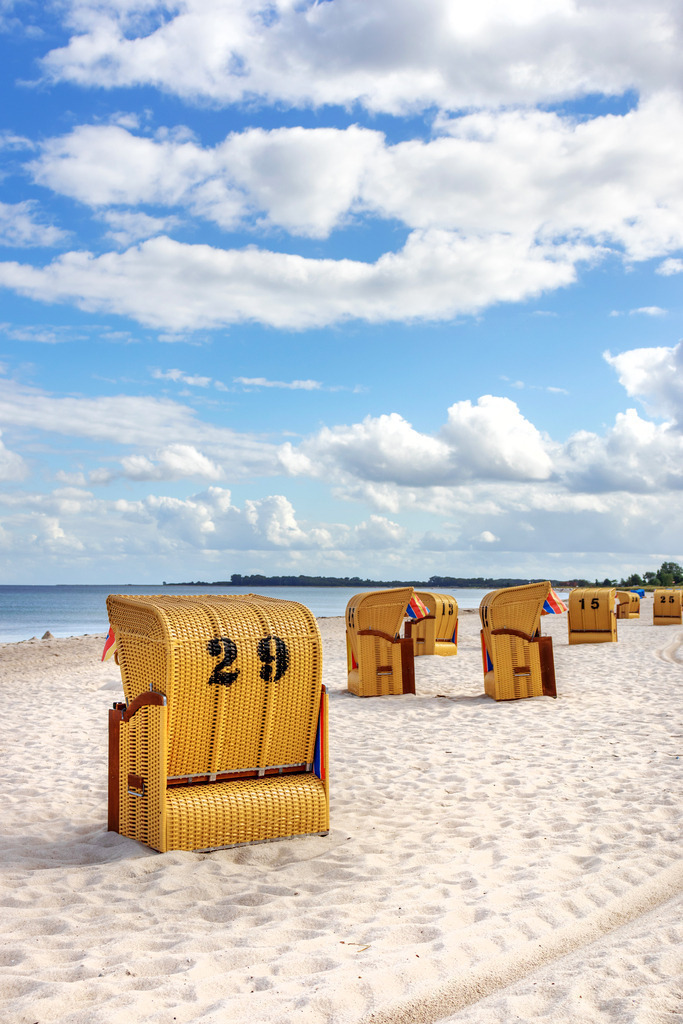 Akustikbild: Strandkörbe am Sandstrand | Dieses Akustikbild im Hochformat zeigt einen schönen sommerlichen Sandstrand mit zahlreichen Strandkörben. Am Himmel sind zahlreiche helle Wolken zu sehen.  - Realisiert mit Pictrs.com