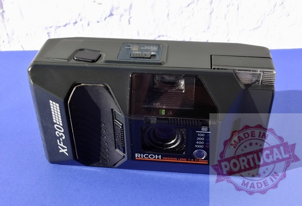 Ricoh XF-30 compact film camera from a vintage era | Ricoh XF-30 35mm point and shoot camera on a blue background - Realisiert mit Pictrs.com