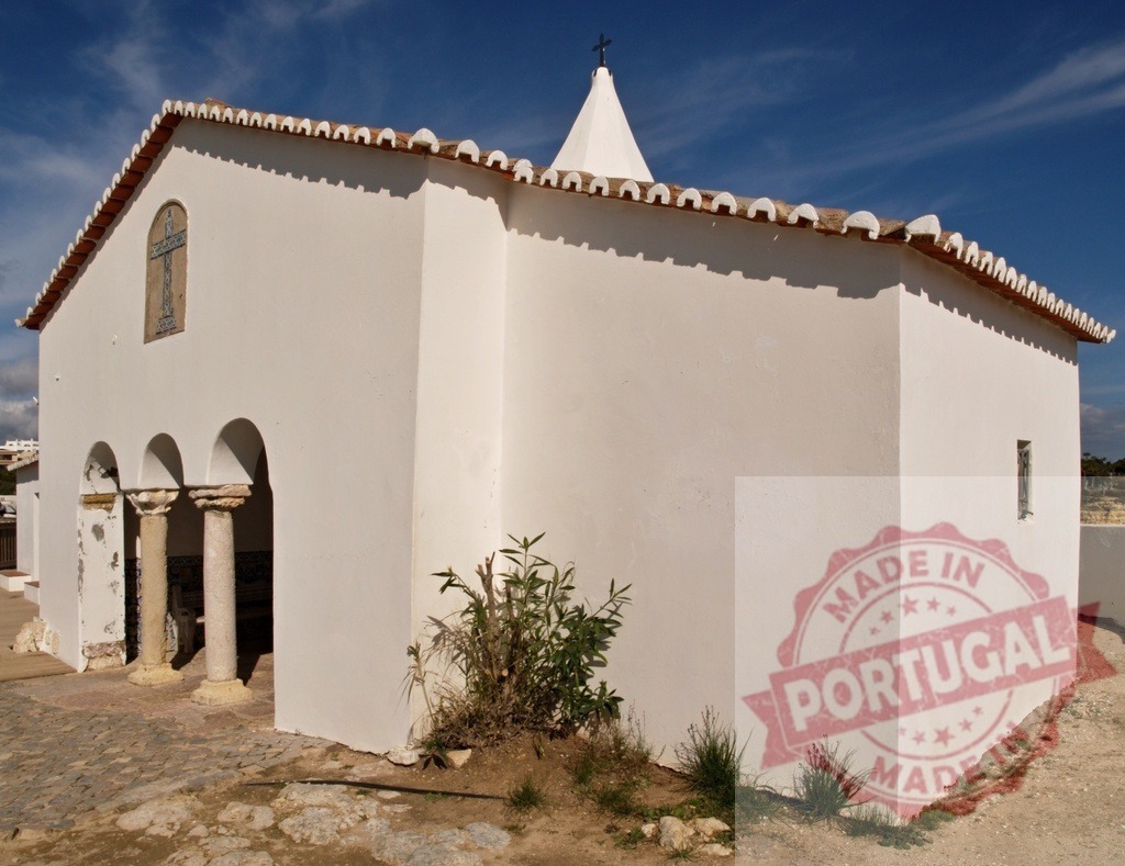 Whitewashed chapel in Algarve, Portugal against blue sky | Whitewashed Christian chapel with traditional roof tiles and archways under a clear blue sky - Realisiert mit Pictrs.com