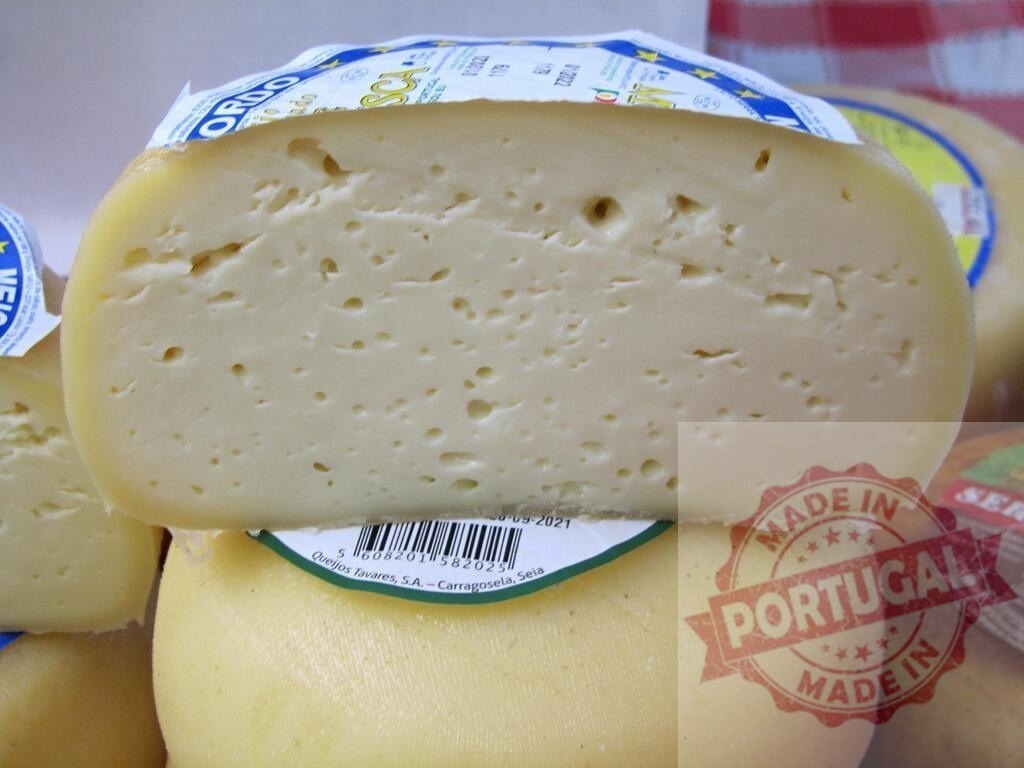 Portuguese Serra da Estrela cheese wheel cut revealing texture | Half wheel of Queijos Tavares cheese showcasing its creamy texture, ready for tasting - Realisiert mit Pictrs.com