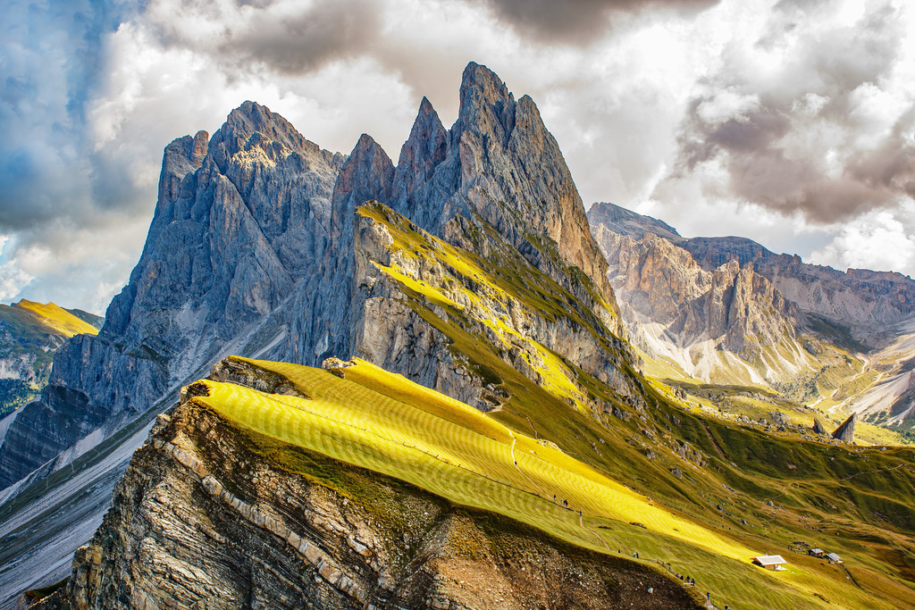Majestät der Dolomiten - Lichtspiel über Seceda | Erleben Sie die majestätische Schönheit der Dolomiten mit diesem atemberaubenden Panorama-Wandbild. Gezeigt wird die berühmte Seceda-Bergkette in Südtirol – mit ihren dramatischen Felsformationen, den sattgrünen Hängen und dem faszinierenden Licht- und Schattenspiel auf der Almwiese. Die gestochen scharfen Details und die intensiven Farben machen dieses Motiv zu einem echten Highlight in jedem Raum. Ein Kunstwerk der Natur, das Ruhe, Weite und alpine Erhabenheit vermittelt.
