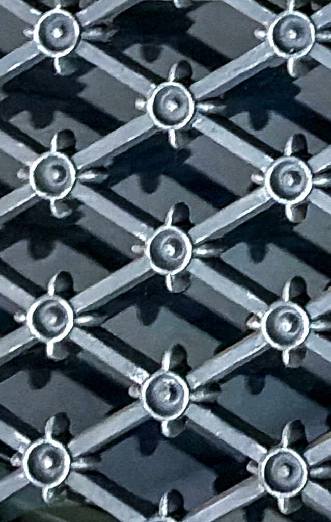 Industrielles Metallgitter | Geometrische Textur Fotokunst | Minimalistische Industrie-Ästhetik für anspruchsvolle Wände. Diese kontrastreiche Nahaufnahme einer geometrischen Metallstruktur fasziniert durch ihre präzisen Linien und die raue, haptische Oberfläche. Als großformatiges Wandbild (besonders spektakulär auf mattem Alu-Dibond) bringt dieses abstrakte Kunstwerk urbane Eleganz und moderne Tiefe in dein Wohnzimmer, Loft oder Büro. - Realisiert mit Pictrs.com