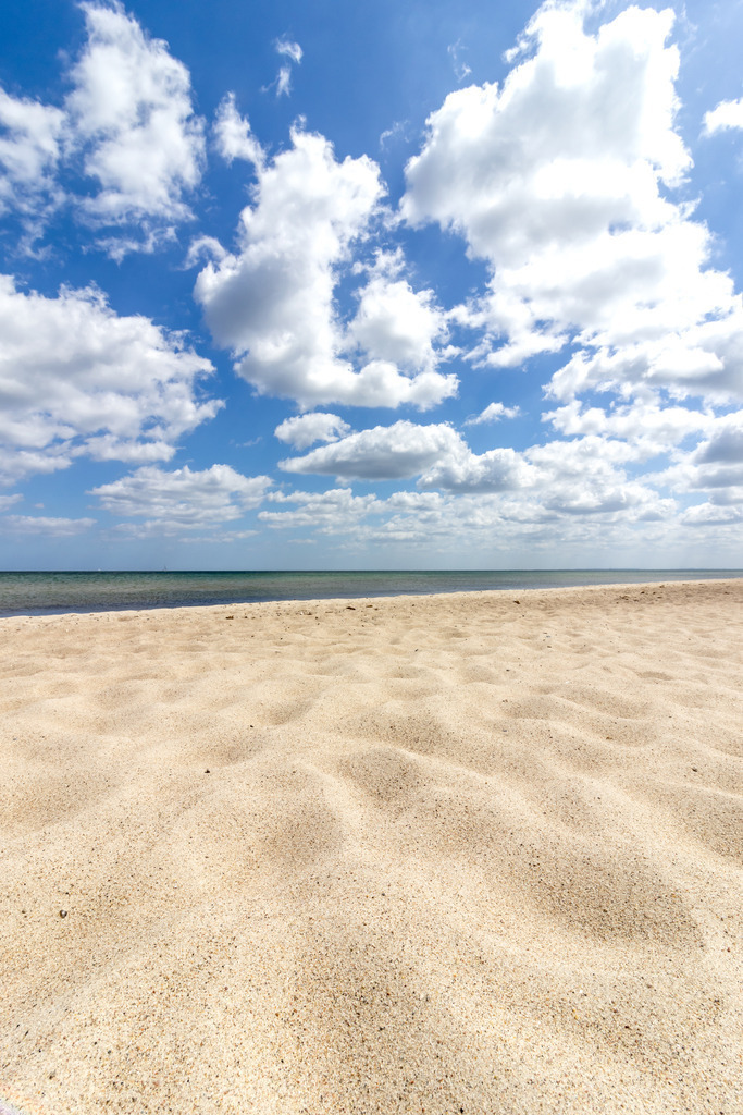 XXL Wandbild: Strandruhe – Wolken über der Ostsee | Dieses Wandbild zeigt eine ruhige Strandszene an der Ostsee mit hellem, strukturiertem Sand im Vordergrund und einem wolkenreichen Himmel über dem Meer. Die Wasseroberfläche ist ruhig, die Wellen sanft, und die Wolken spiegeln sich leicht im Licht der Sonne. Der Himmel wechselt von Blau zu Weiß, das Licht ist klar und freundlich – ein typischer Sommertag an der Küste. Die Komposition lebt vom Spiel aus Textur, Weite und Licht.Ideal für alle, die mit einem Wandbild norddeutsche Küstenruhe in ihre Räume holen möchten. - Realisiert mit Pictrs.com