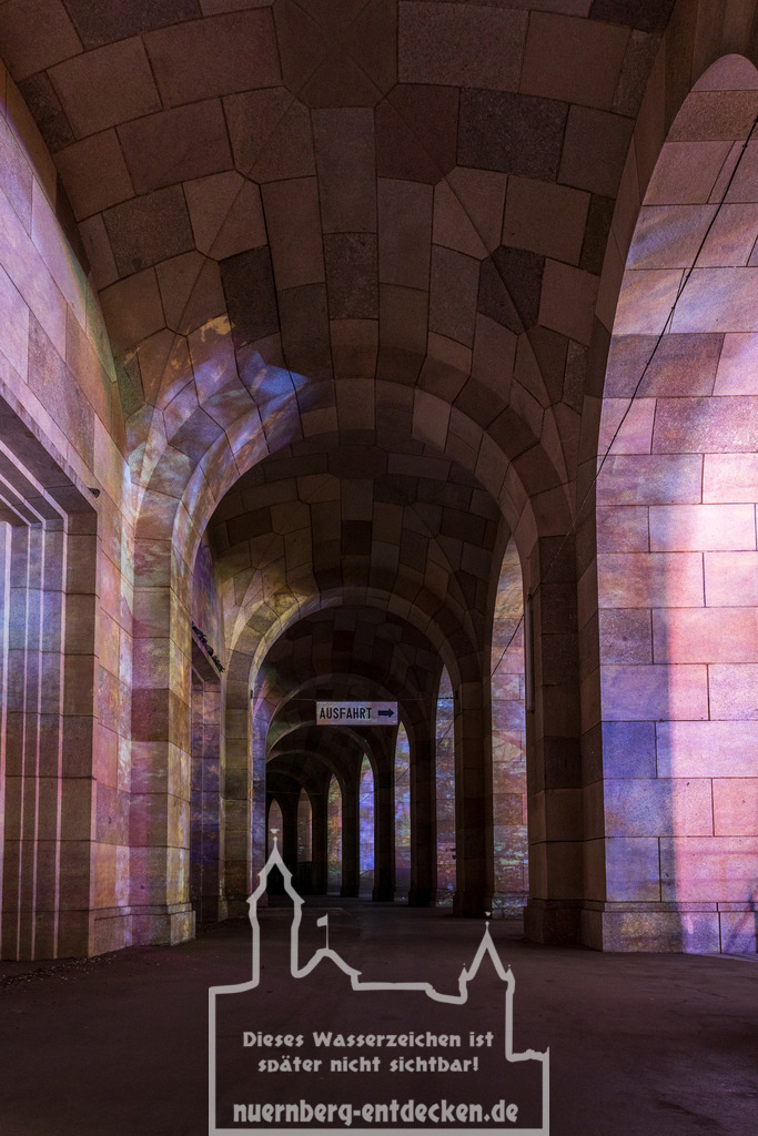 Kongresshalle bunt ausgeleuchtet - Teil 1 | Der imposante Rundgang, um die alte Kongresshalle auf dem Reichsparteitagsgelände in Nürnberg bei Nacht. Durch das in der Nähe stattfindende Frühlingsvolksfest wird der Gang bunt ausgestrahlt.  - Realisiert mit Pictrs.com