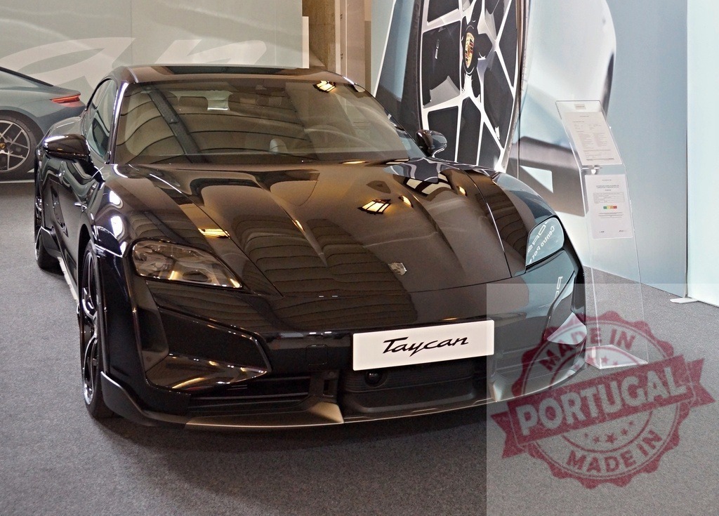 Porsche Taycan electric sports car in showroom | Black Porsche Taycan electric vehicle presented in a modern car showroom environment - Realisiert mit Pictrs.com