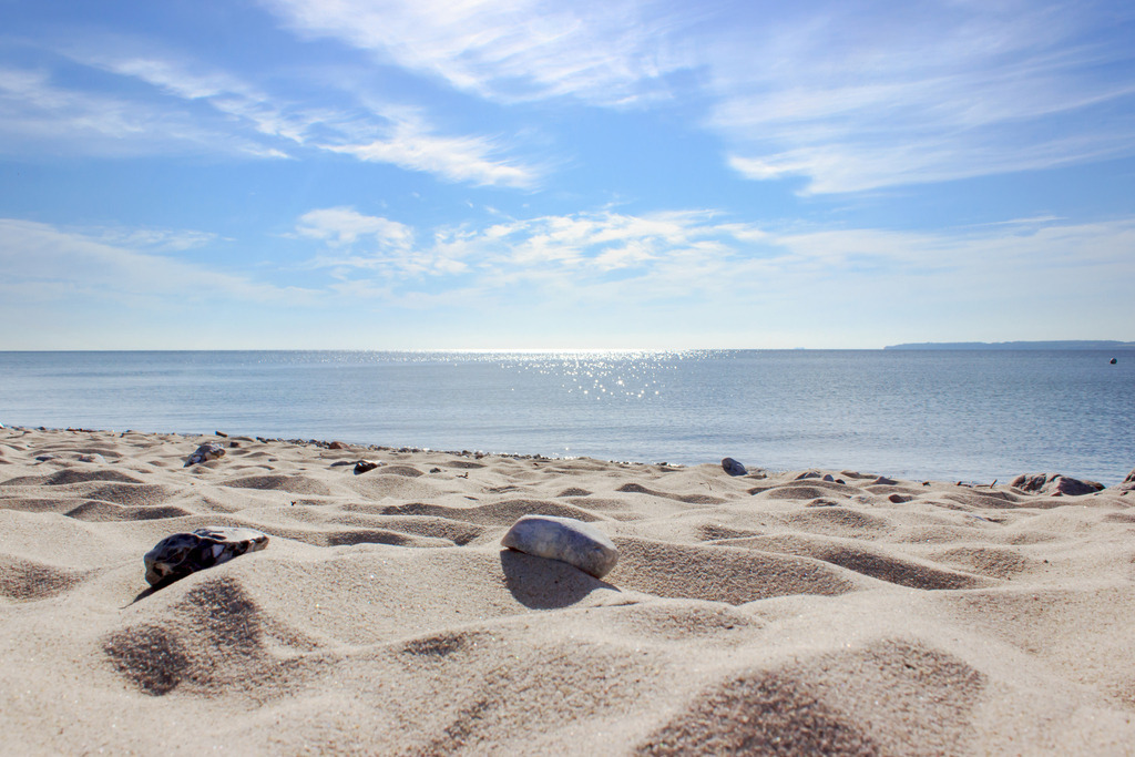 Wandbild: Sandstrand in Langholz | Dieses Wandbild im Querformat zeigt den Sandstrand in Langholz im Sommer. Im Vordergrund ist der Sandstrand in Nahaufnahme zu sehen. Am blauen Himmel sind einige sommerliche Wolken zu sehen.  - Realisiert mit Pictrs.com