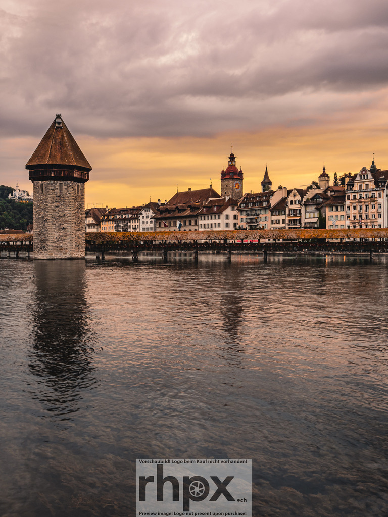 Kapellbrücke im Abendlicht | Wahrzeichen. Abendlicht. Geschichte.
Die historische Kapellbrücke in Luzern präsentiert sich in sanftes, warmes Abendlicht getaucht. Ruhig spiegelt sich der markante Wasserturm in der Reuss und strahlt zusammen mit der Altstadt eine zeitlose Eleganz aus.
Wähle unter "Produktauswahl" dein Wunschformat: Vom klassischen Wandbild über Puzzle &amp; Tassen bis zum digitalen Download (z.B. als Handy-Hintergrund).

 - Realisiert mit Pictrs.com