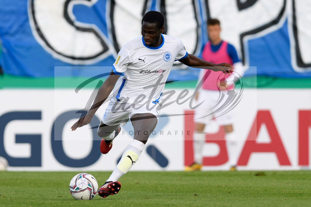 LOTKSC20210809_152 | Fussball, Herren: Komlan Fionouke (Sportfreunde Lotte) in Aktion, am Ball, Einzelaktion beim Spiel der 1. Runde im DFB-Pokal zwischen SF Lotte und Karlsruher SC im Stadion am Lotter Kreuz am 09.08.2021 in Lotte, Deutschland.DFB / DFL REGULATIONS PROHIBIT ANY USE OF PHOTOGRAPHS AS IMAGE SEQUENCES AND/OR QUASI-VIDEO. - Realisiert mit Pictrs.com