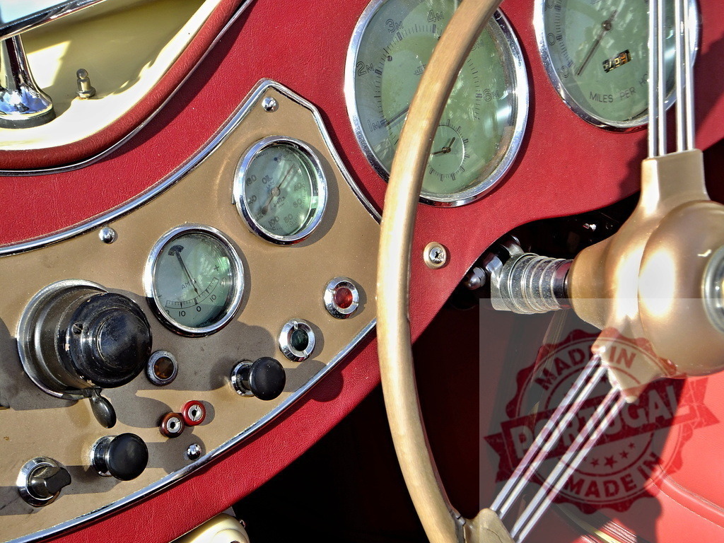 Dashboard and steering wheel of a vintage MG TD sports car showing gauges and switches | Close-up of the dashboard and steering wheel of a vintage MG TD sports car, highlighting its classic design and gauges - Realized with Pictrs.com