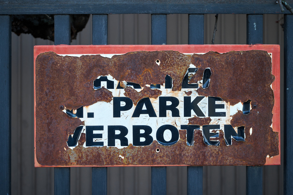 Rostiges Schild mit Halte- und Parkverbot | Wien, Austria - February 28, 2023: Rostiges Schild mit Halte- und Parkverbot an einem Eisenzaun. - Realisiert mit Pictrs.com