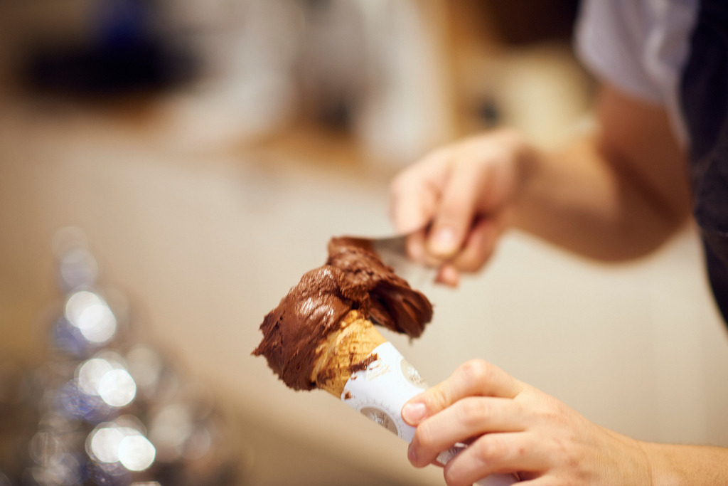 Gelateria la Romana, Schokoladeeis in Tuete | Wien, Austria - December 21, 2017: Gelateria la Romana; eine Eistüte wird mit Schokoladeeis gefüllt. - Realisiert mit Pictrs.com