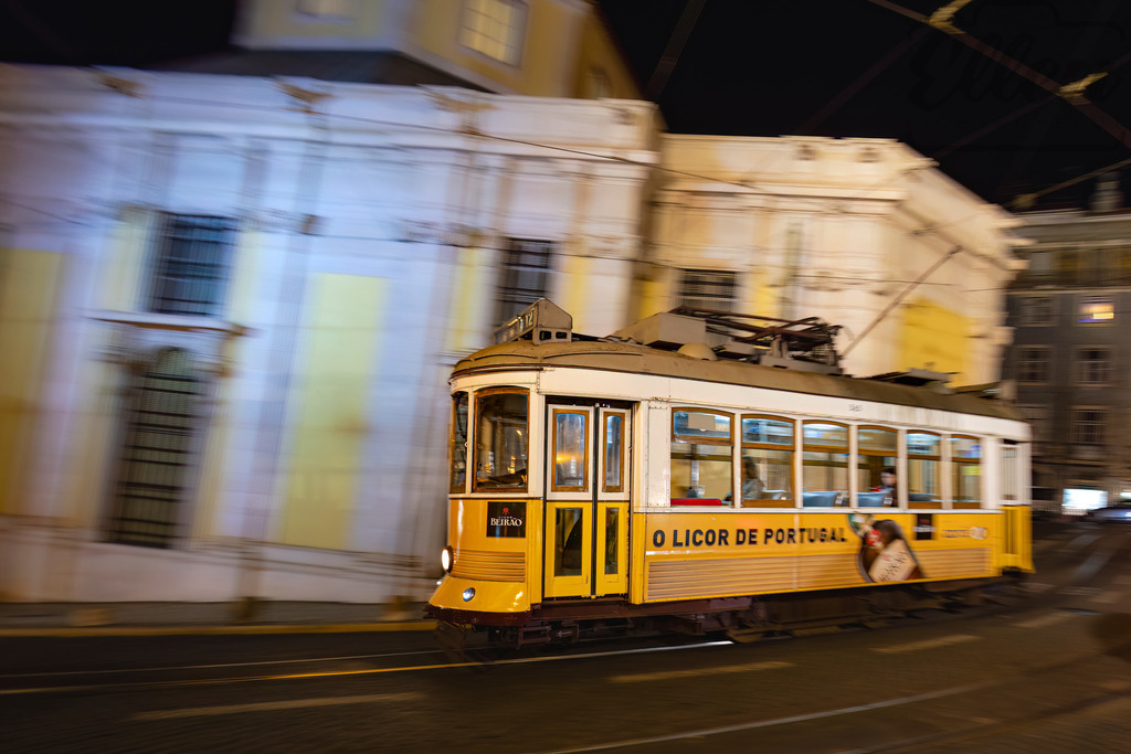Night Ride through Lisbon | A classic yellow tram glides through Lisbon’s illuminated streets, carrying the city’s rhythm into the night — where tradition meets motion and time feels suspended. - Realisiert mit Pictrs.com