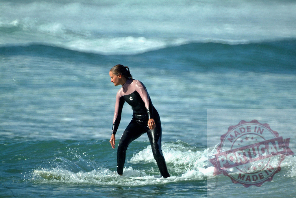 Young surfer woman riding a wave in the ocean | Surfer woman riding a surfboard on a wave in the ocean - Realized with Pictrs.com
