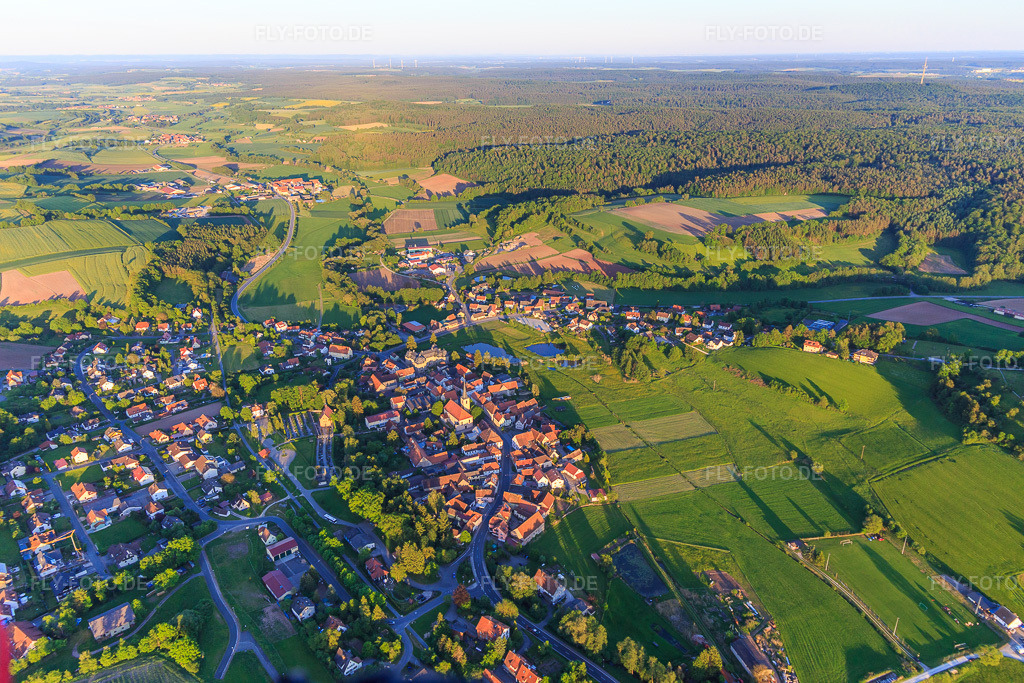 Luftbild: Dorfübersicht mit Kirche St. Jakobus der Ältere und Schloß Burgwindheim in Burgwindheim im Bundesland Bayern in Deutschland. – Foto: IMG_100432.jpg vom 27.05.2017 durch Werner Riehm/FLY-FOTO.de – Auflösung des Originals: 5472 x 3648 px – SEELSORGEBEREICH-STEIGERWALD.DE – Burgen und Schlösser