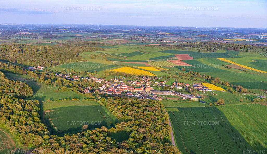 Aerial view: View of the town from the west in Frémestroff in the state Moselle, France. – Photo: IMG_154767.jpg taken on 04/17/2026 by Werner Riehm/FLY-FOTO.com – Resolution of the original: 6000 x 3469 px